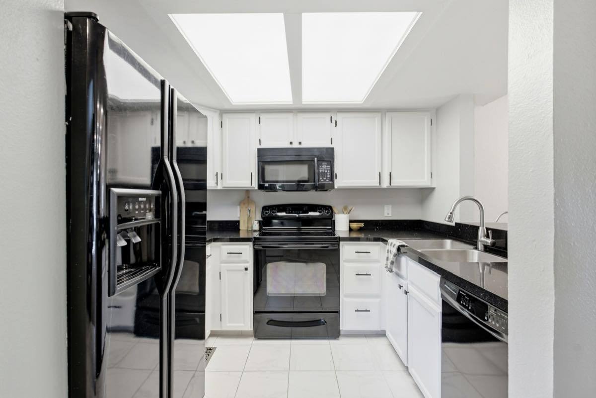 Galley kitchen lit by a large flush ceiling light panel