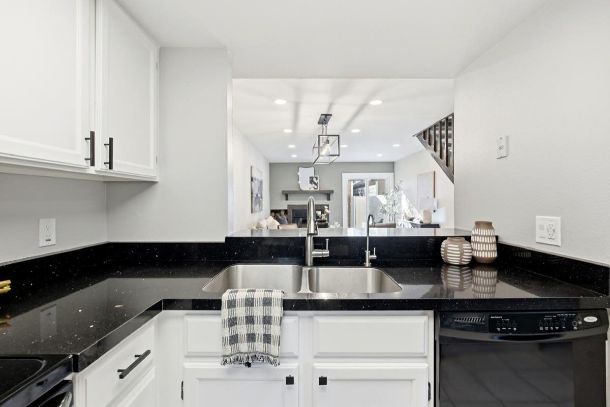 Kitchen and living space with recessed ceiling lights and a caged pendant light over the dining area